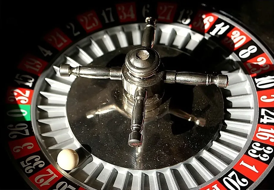 Photograph showing the numbered pockets, spindle and ball of a physical roulette wheel.
